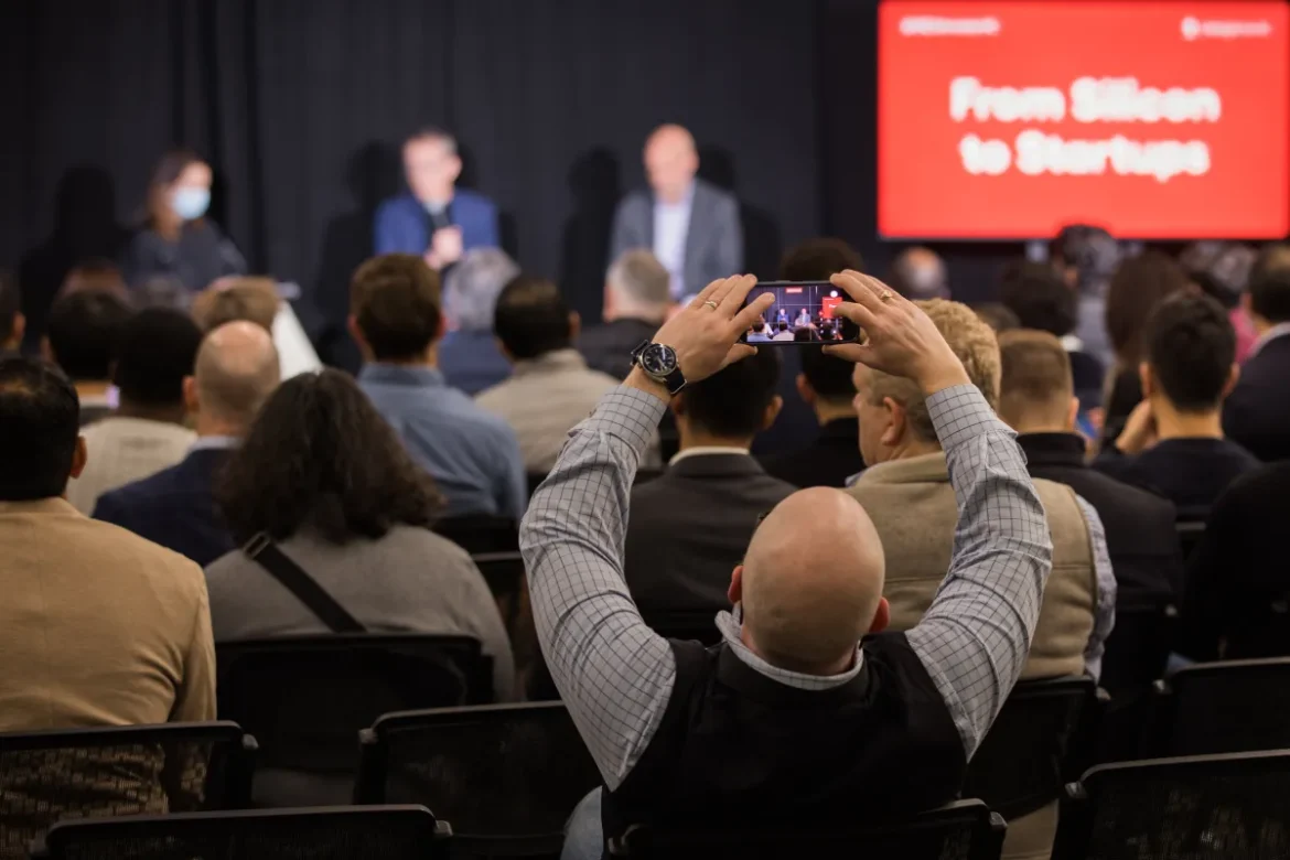 An attendee at a StrictlyVC 2025 event taking a photograph