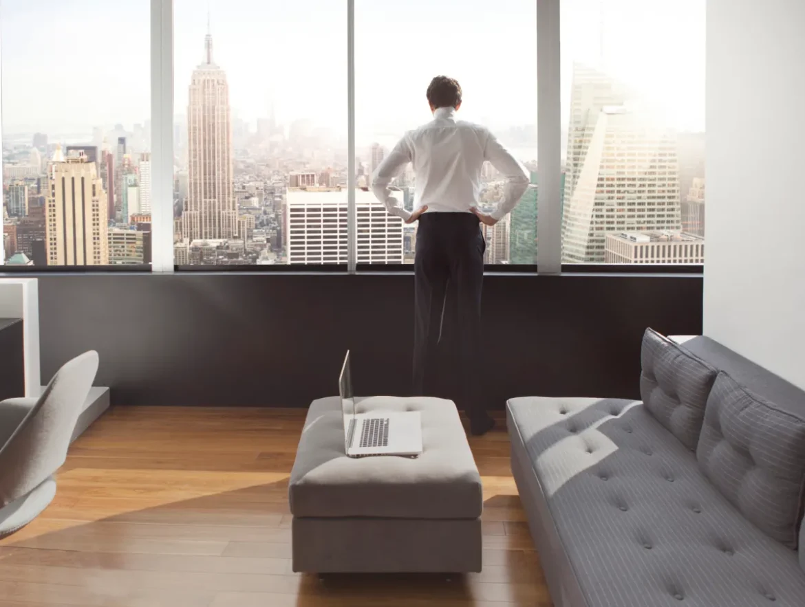 Young man looking out at city skyline.